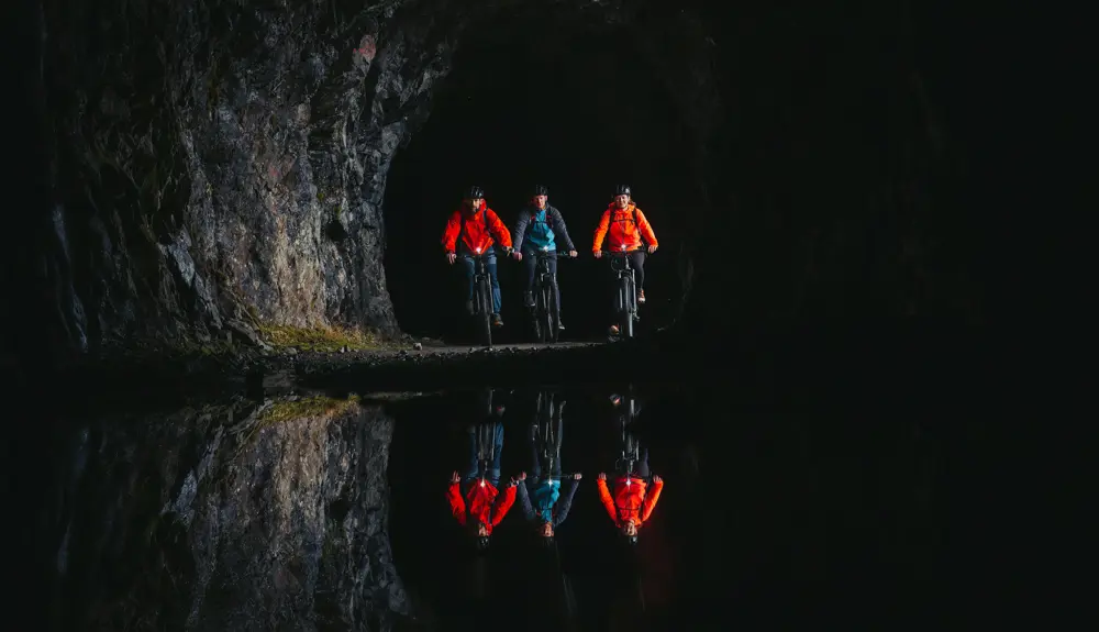 Cyclists in one of the tunnels along Tusenmeteren in Øvre Årdal