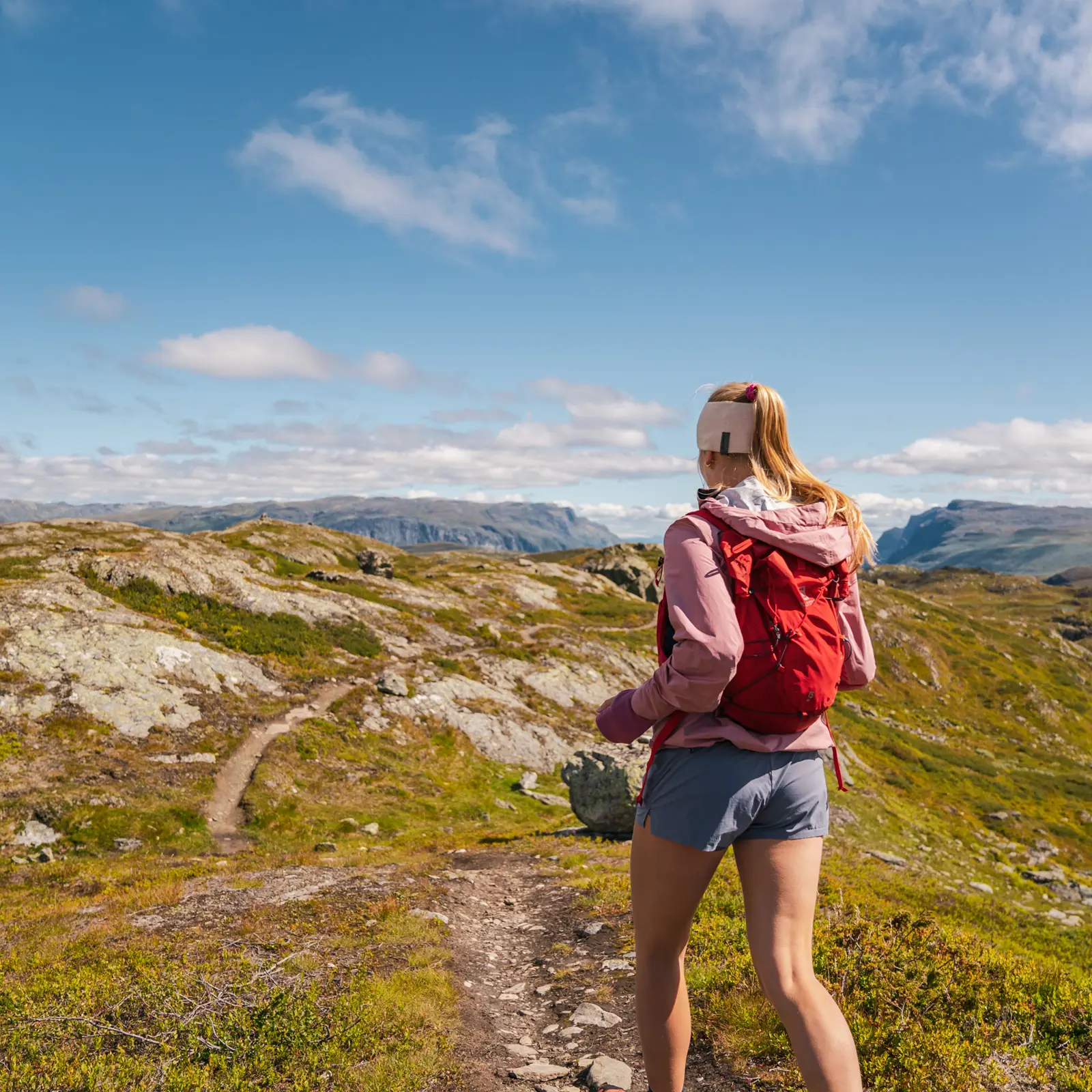 Trail runner in the high mountains – young woman running at Børrenøse