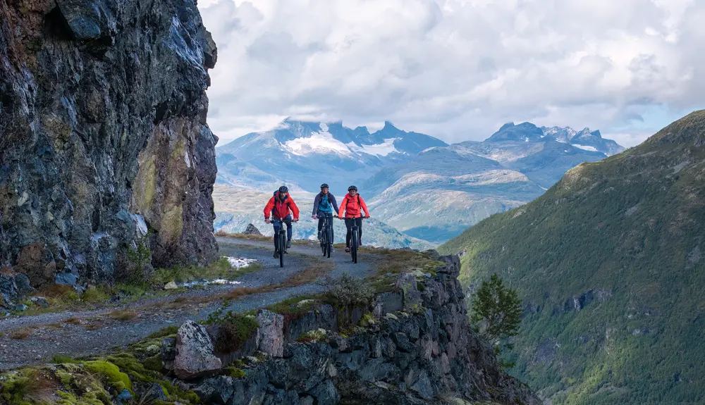 Cyclists on the 1000-meter Road with the Hurrungane mountains as a backdrop