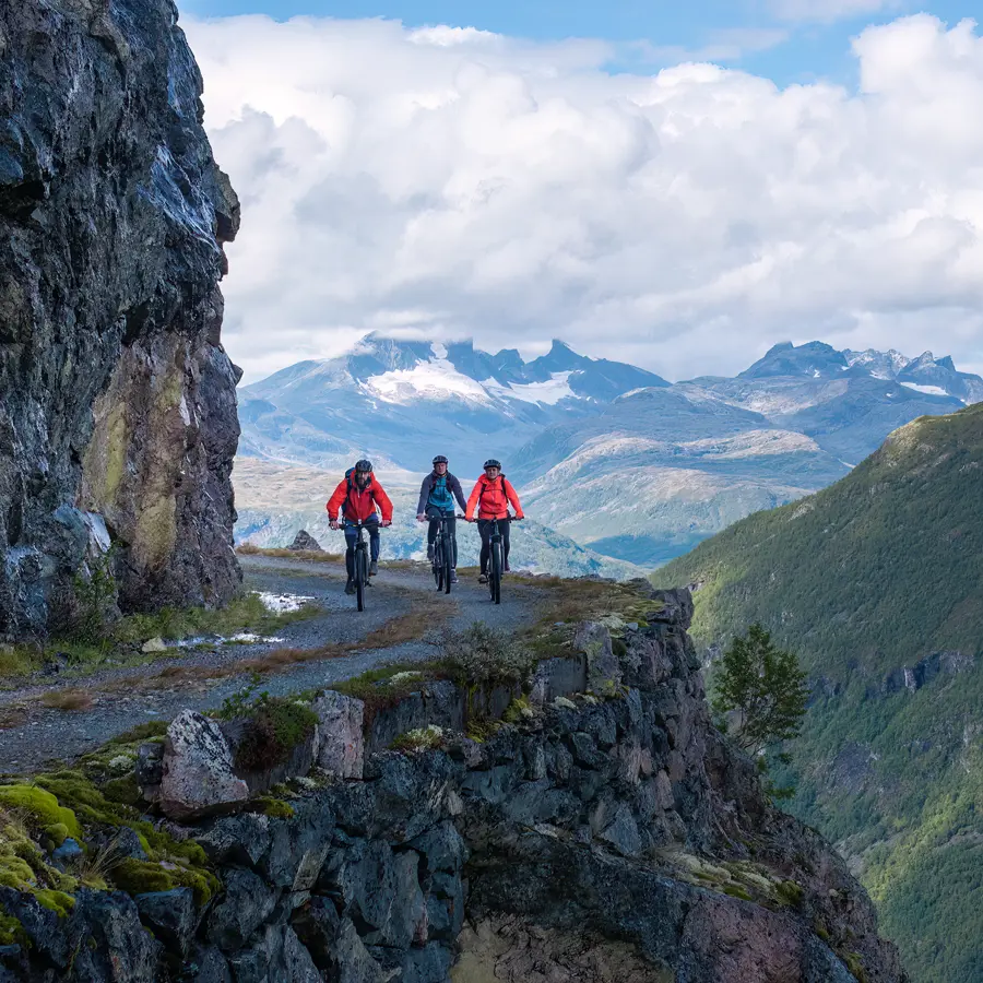 Cyclists on Tusenmeteren with the mountains of Hurrungane as a backdrop