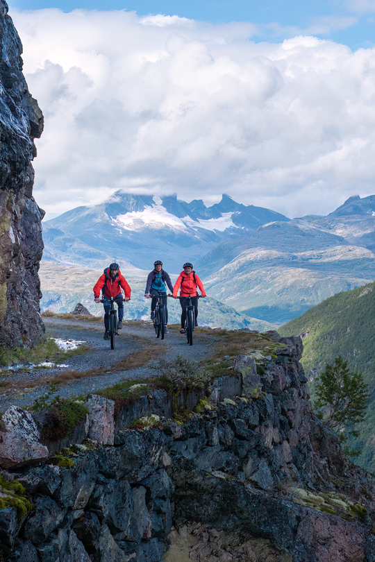 Cyclists on Tusenmeteren with the mountains of Hurrungane as a backdrop