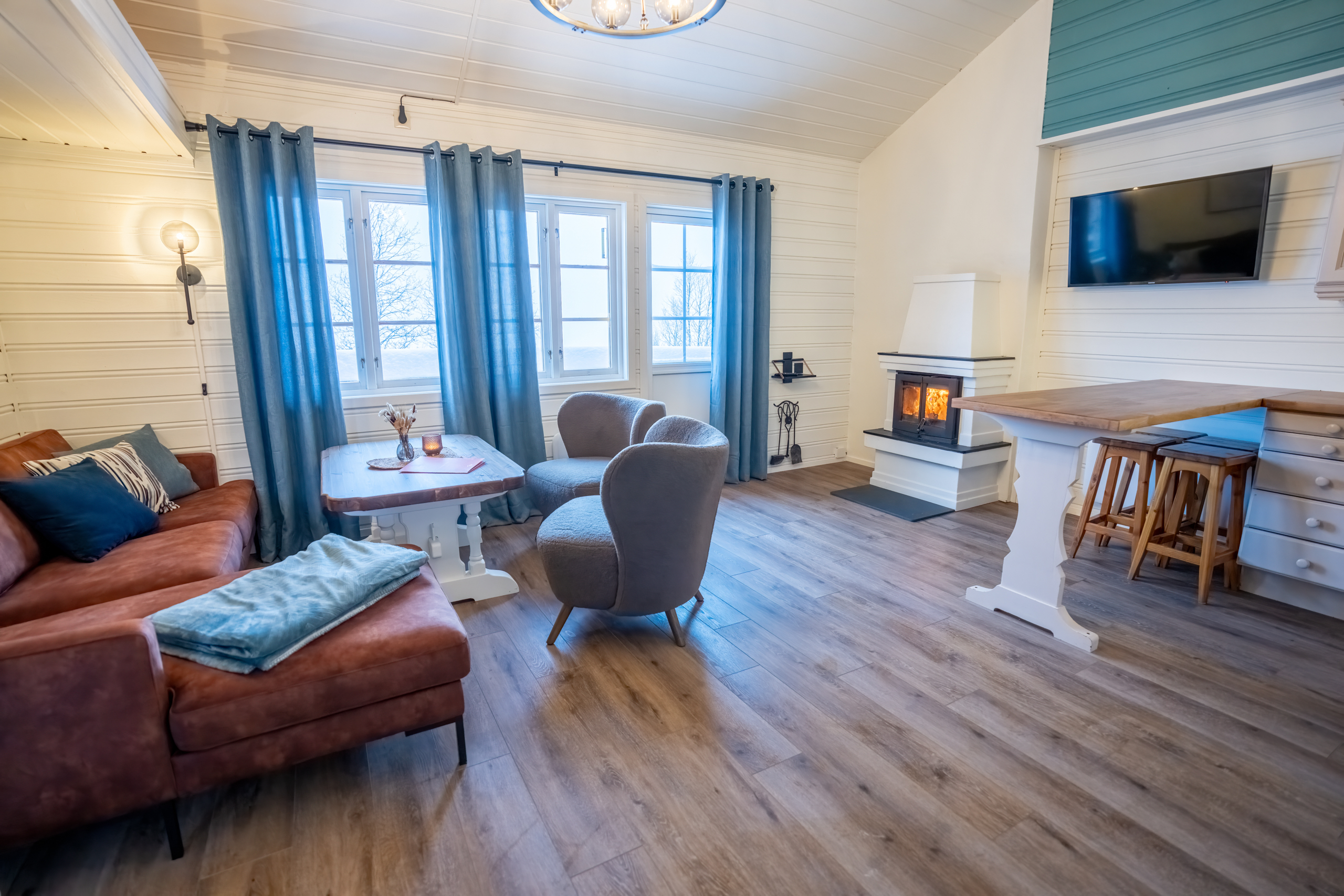 Open living room and kitchen with cozy fireplace in the terraced cabins at Filefjellstuene