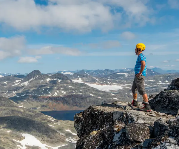 Topptur med guide fra Tyin Aktiv – deltaker ser på utsikten fra toppen av Falketind 