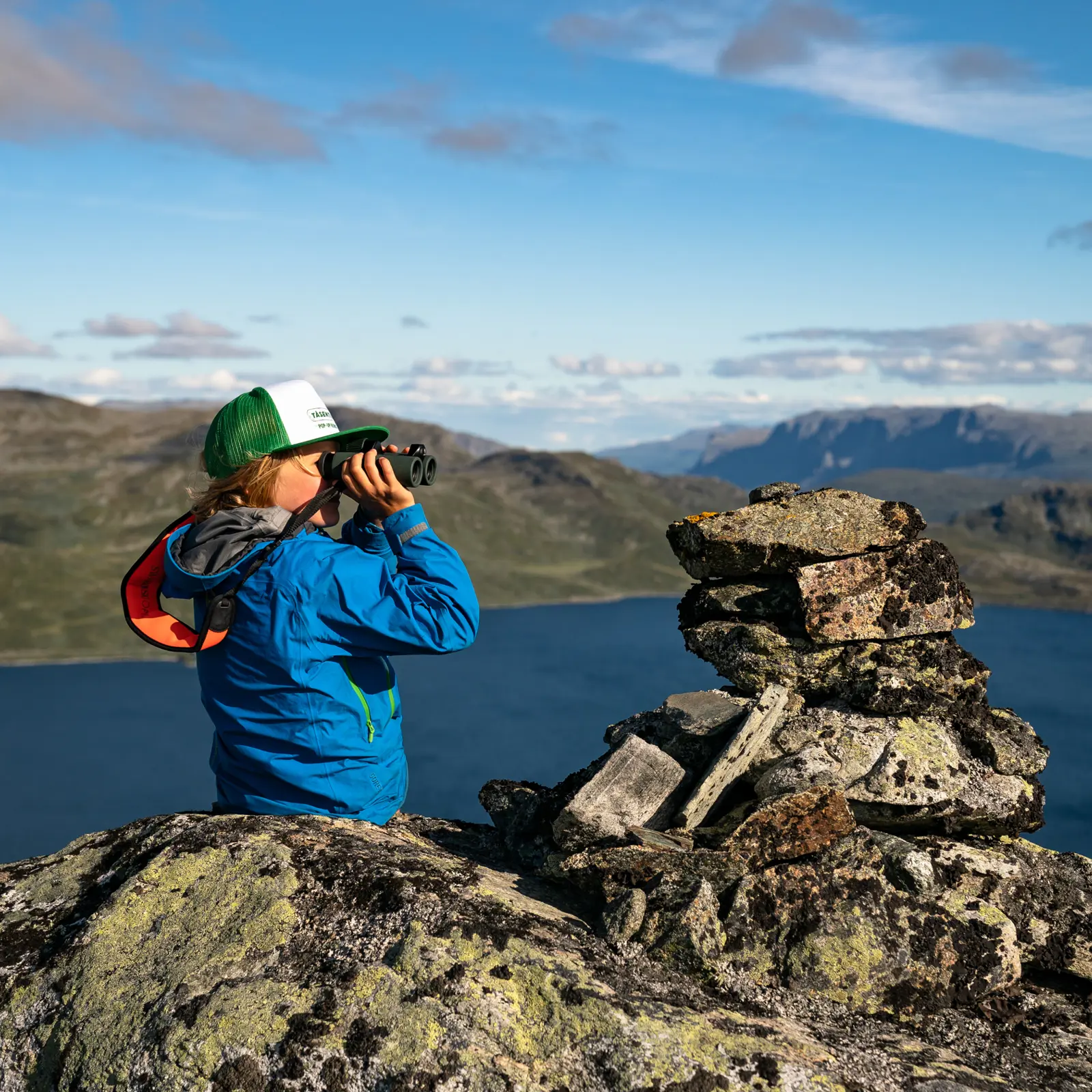 Gutt ser i kikkert på Jotunheimen sine majestetiske fjell