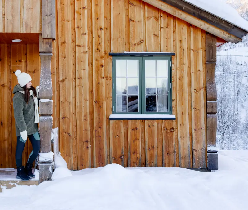 Woman standing at the front door of an apartment at Filefjellstuene in a winter landscape