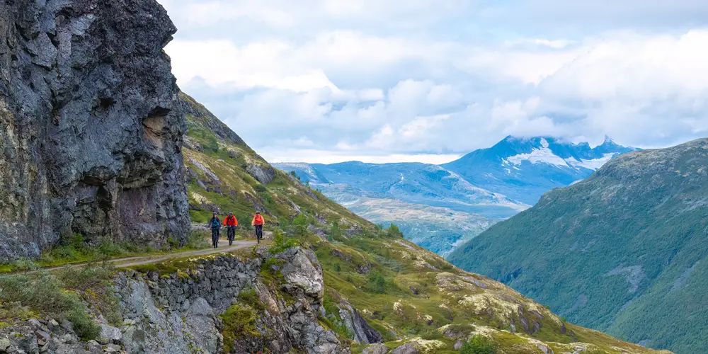Cyclists on Tusenmeteren with the mountains of Hurrungane as a backdrop