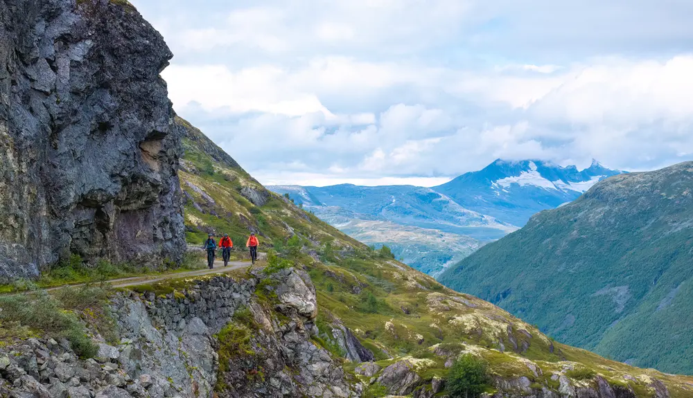 Cyclists on Tusenmeteren with the mountains of Hurrungane as a backdrop