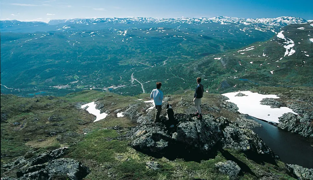 Vandrere ser på udsigten mod Tyinkrysset fra Stølsnøse