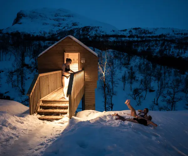 Venner bader i sneen uden for saunaen på Filefjellstuene en vinteraften