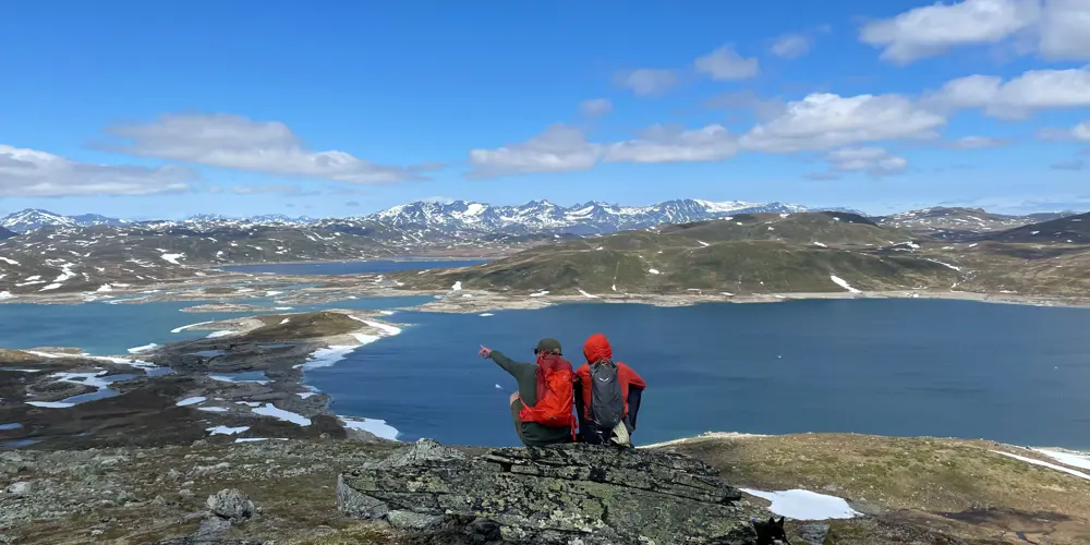 Turgåere nyter utsikten mot Jotunheimen på vei til Hødntind