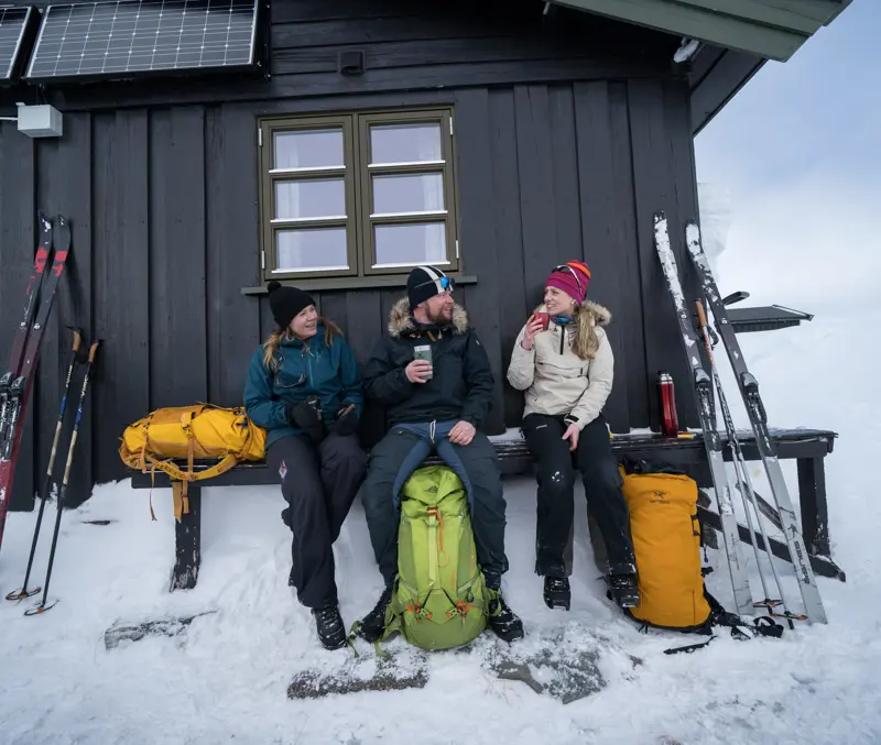 Skiers on mountain skis take a break outside Sulebu