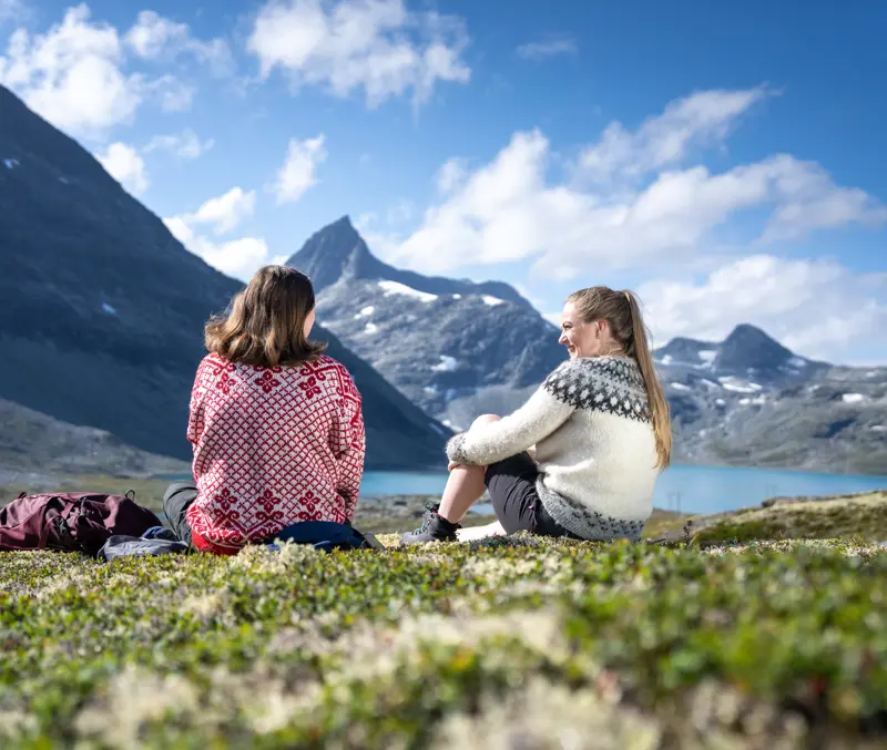 Friends taking a break during a hike in Koldedalen, with Falketind in the background.