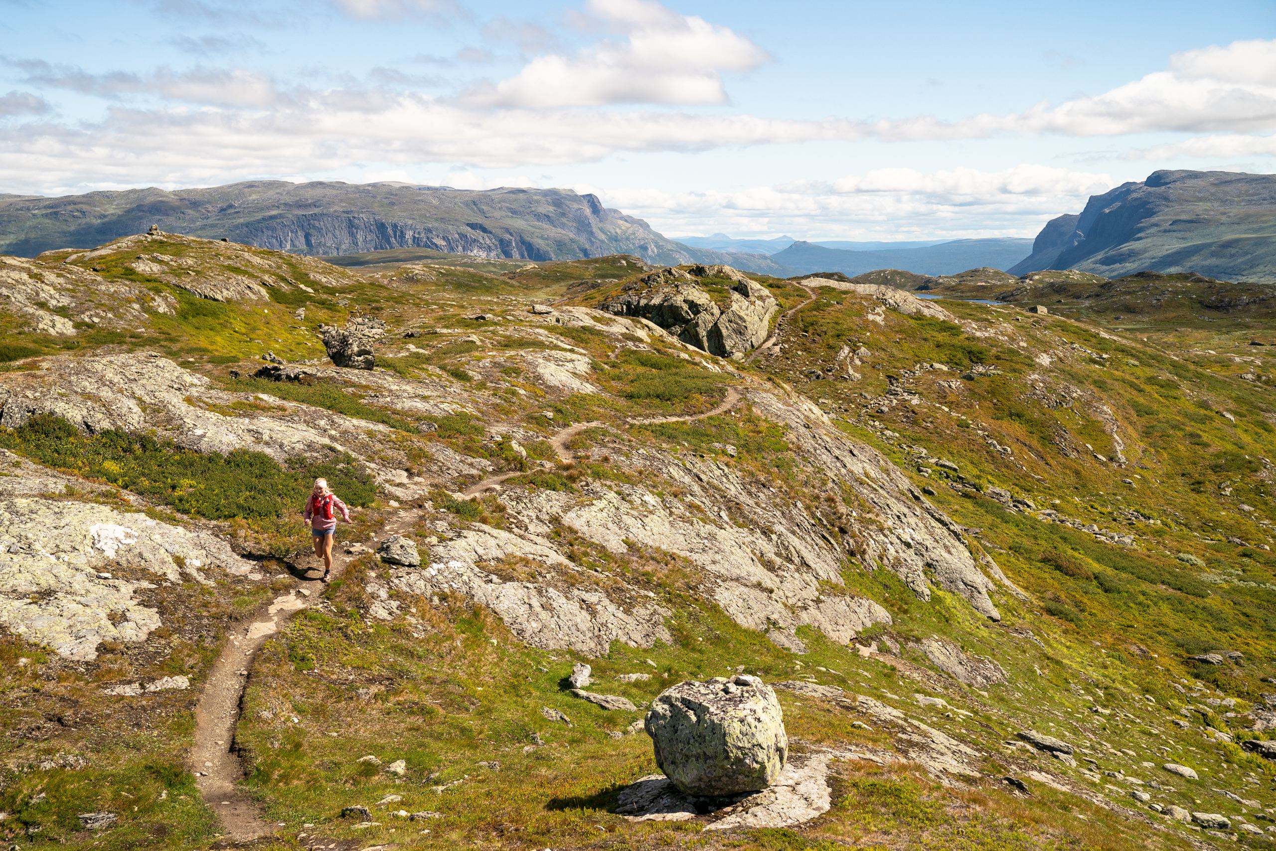 Trail runner in the high mountains – young woman running at Børrenøse