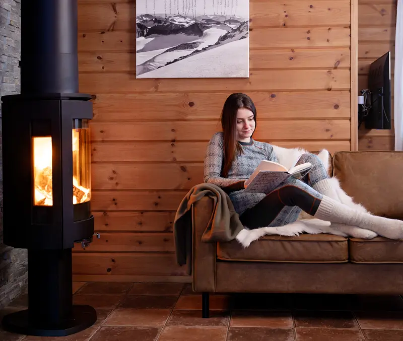 Woman reading a good book by the fireplace in one of the apartments at Filefjellstuene