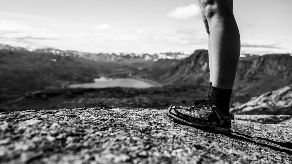Trail runner in the high mountains – young woman running at Børrenøse